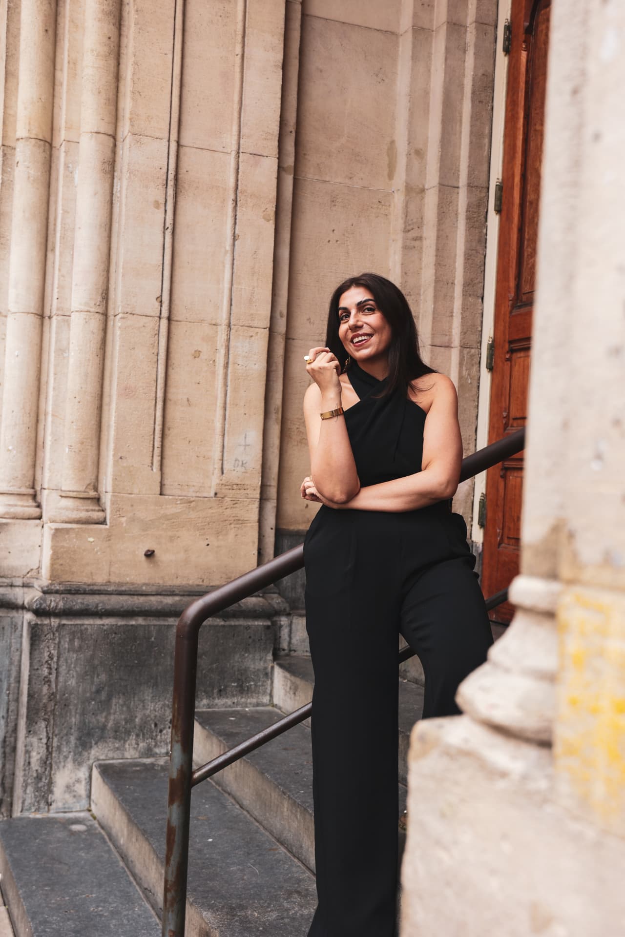 Hatice Tekin, founder of The Untamed Founder, smiling beside classical stone columns