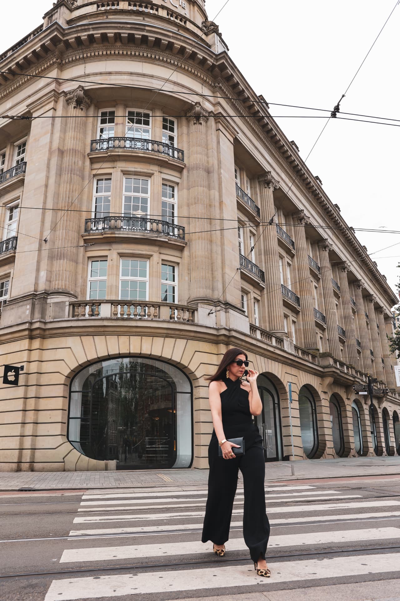 Hatice Tekin crossing a street in an elegant black jumpsuit
