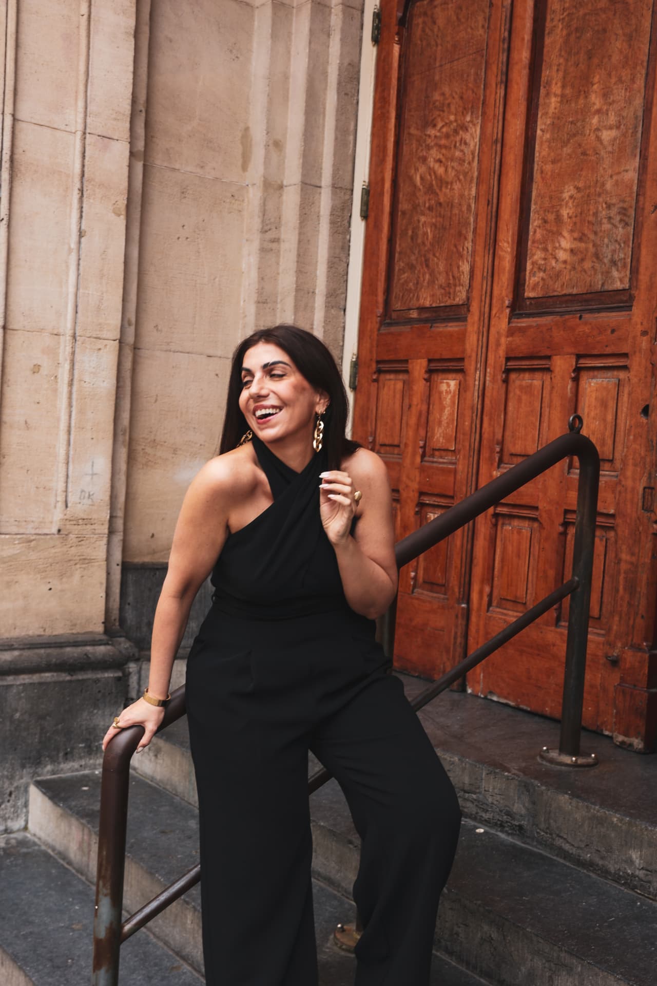Hatice Tekin laughing on stone steps in a classical setting